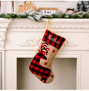 Close-up of personalized Christmas stocking with red plaid reindeer and Nathan embroidery