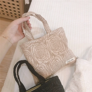 Close-up of fabric tote bag with 3D rose texture and simple wish woven label detail