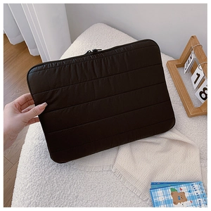 Close-up of black quilted laptop sleeve with horizontal stitching and zipper closure