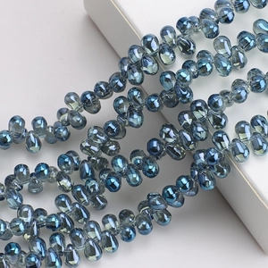 Macro detail of 6x9mm teardrop glass crystal beads with blue iridescent finish for jewelry