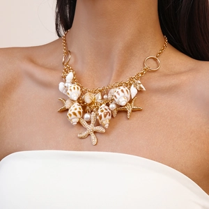 Close-up of golden nautical necklace with shells, starfish charms and faux pearls