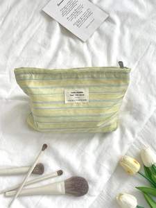 Close-up of green striped canvas makeup bag with soft texture and tulip decor