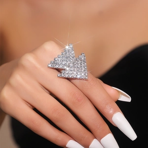 Detail of a large geometric crystal ring featuring a sparkling silver-tone design on a model