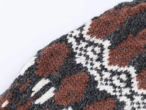 Macro shot of three-color jacquard knit fabric showing soft texture and geometric patterns