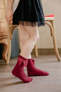 Detail of burgundy cotton princess socks with large satin bow and ruffled trim