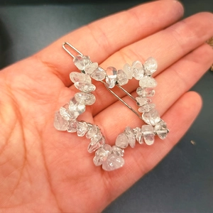 Handmade star-shaped hair clip with natural clear crystal stones held in a person's palm