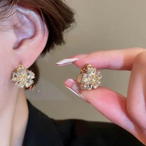 Detail of floral cat eye stone earrings with double-sided diamonds and gold finish