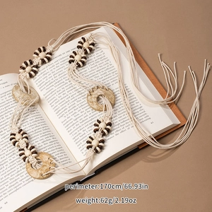Detail of bohemian hand-woven belt with ivory and brown beads on a book background