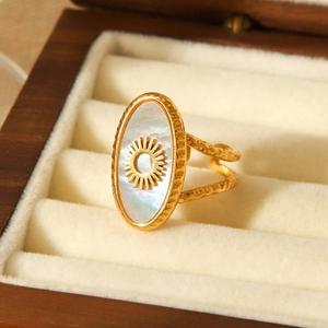 Macro detail of gold stainless steel sun ring with white shell inlay in a velvet box