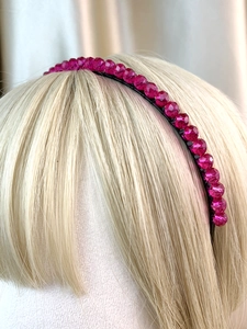Detail of rose red faceted beads on a slim metal headband shown on a mannequin