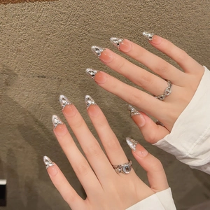 Handmade blush pink press-on nails in long almond shape with silver glitter and bows
