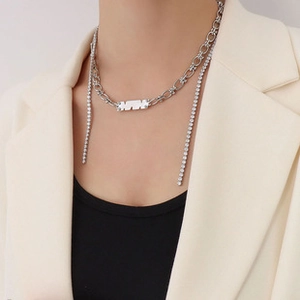 Macro shot of silver metal chain with rhinestone tassels and a rectangular plaque detail