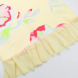 Détail macro du tissu à imprimé floral avec ourlet à volants en maille jaune clair