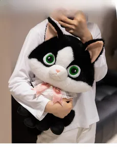 Detail of tuxedo cat plush with green eyes, pink ribbon bow, and lace collar accessory