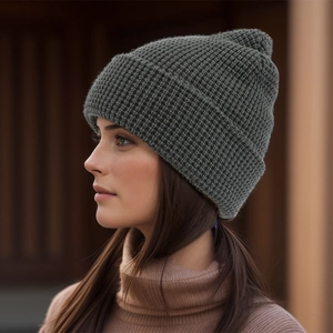 Nahaufnahme einer dunkelgrauen Strickmütze mit Waffelstruktur getragen von Modell