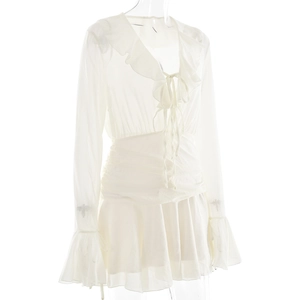 Detail of white chiffon dress featuring V-neck ruffle edges and lace-up front design