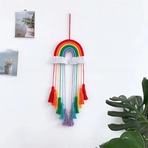 Close-up of handmade rainbow wall hanging with colorful cotton fringe for home decor