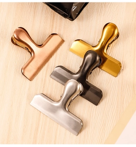 Detailed macro view of four metallic clips in rose gold, gold, grey and silver finishes