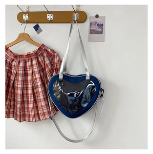 Detail of a navy heart-shaped ita bag with a clear PVC window and adjustable strap