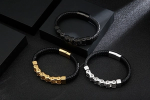 Three men's stainless steel and leather bike chain bracelets on black geometric stands