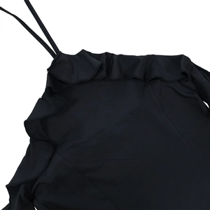 Détail de la robe licou noire élégante montrant l'encolure à volants et fines bretelles