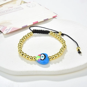 Detail of adjustable woven bracelet with golden beads and blue heart evil eye charm