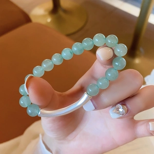 Detail of green aventurine beaded bracelet featuring a matte silver curved metal tube