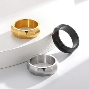 Brushed titanium steel rings for men in gold, silver, and black on geometric pedestals