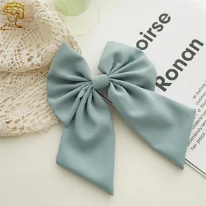 Macro detail of elegant light blue double-layered bow hair clip in soft twill fabric