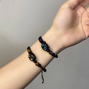 Matching black cat couple bracelets with woven rope and blue or yellow eyes