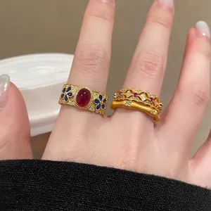 Detail of vintage gold s925 silver rings with red gemstones and enamel bamboo design