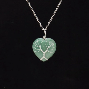 Macro detail of handmade silver wire wrapped Tree of Life on green stone heart pendant