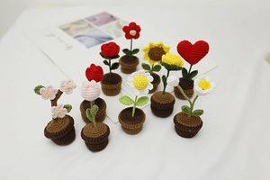 Detailed group view of colorful handmade crochet potted flowers including roses and daisies