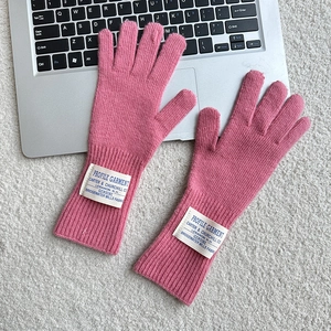 Pink knitted fingerless wool gloves with ribbed cuffs and white fabric labels