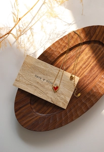 Macro detail of red heart pendant necklace in gold-plated stainless steel with chain