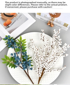 Detail view of artificial blue and white berries on a branch for Christmas home decor