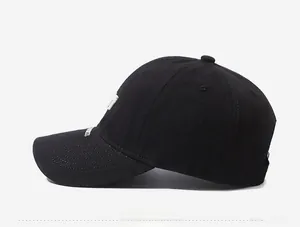 Close-up of black baseball cap with white letter embroidery and premium cotton texture