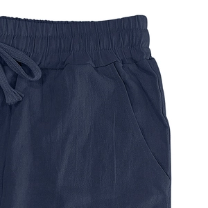 Detail of navy linen trousers showing elastic waistband, drawstring, and fabric texture
