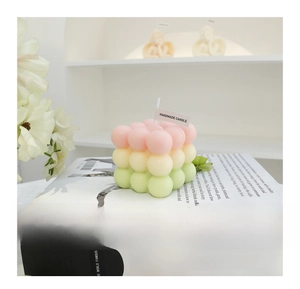 Detailed view of handmade gradient bubble cube candle in pink, yellow and green colors