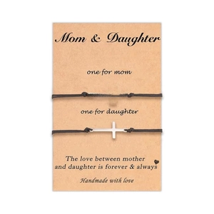 Détail de l'ensemble de bracelets mère-fille avec croix argentées sur carte cadeau