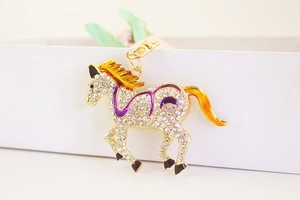 Detail of running horse keychain with sparkling rhinestones and colorful enamel accents