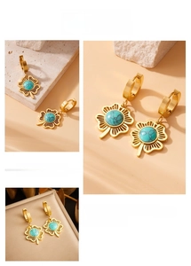 Detailaufnahme der goldenen Kleeblatt-Ohrringe mit runden Türkis-Steinen und Vintage-Design