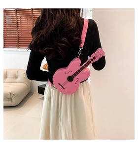 Rear view of a model wearing the pink guitar-shaped leather crossbody bag in a room