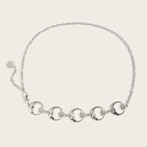 Détail macro d'une chaîne de taille en métal argenté avec pendentifs lune et étoile