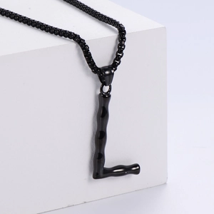 Vue macro du pendentif lettre L 3D avec texture bambou sur collier à billes noires