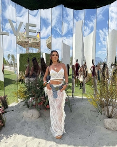 Dettaglio del set crop top in pizzo bianco e gonna lunga con accessori stile bohémien