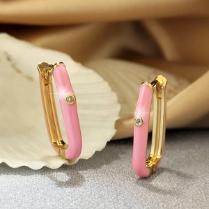 Macro detail of gold-plated earrings with pink enamel and sparkling cubic zirconia