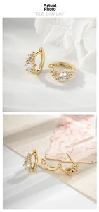Macro shot of gold huggie hoop earrings with micro-set zircon and secure clasp closure