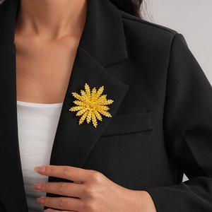 Golden snowflake brooch with matte metal texture pinned on a formal black suit lapel