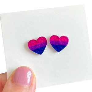 Détail de boucles d'oreilles cœurs à paillettes dégradées en rose, violet et bleu